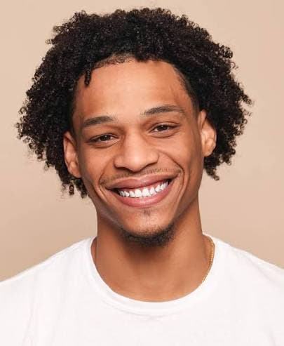 Portrait of Shahid Hinton smiling in a white t-shirt
